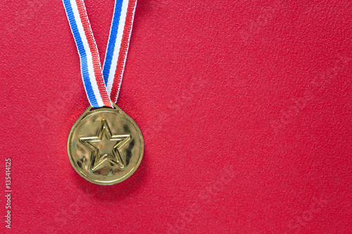 Gold medal on a red background. Winning and achievement concept