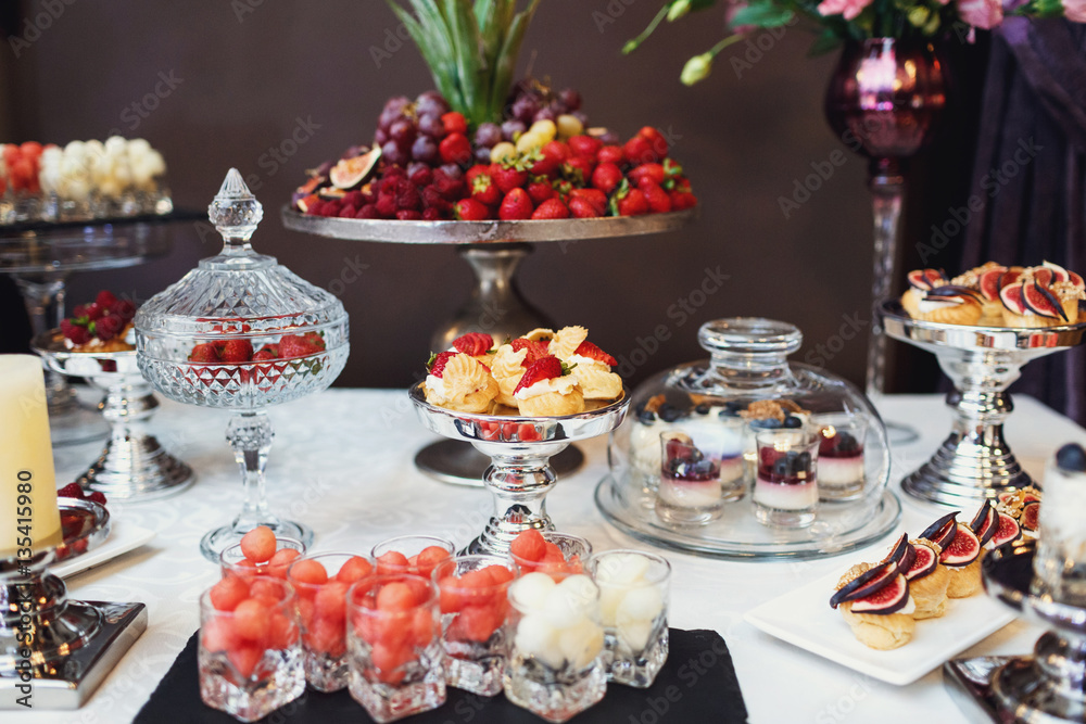 Steel dishes with legs and tasty desserts on them Steel dishes with legs and tasty desserts on them