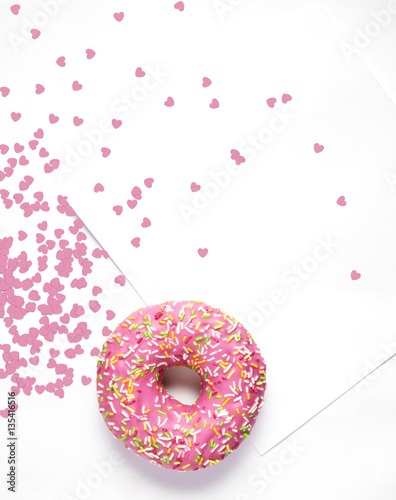 Sweet love / Creative concept photo of  a donut with hearts and card on white background.