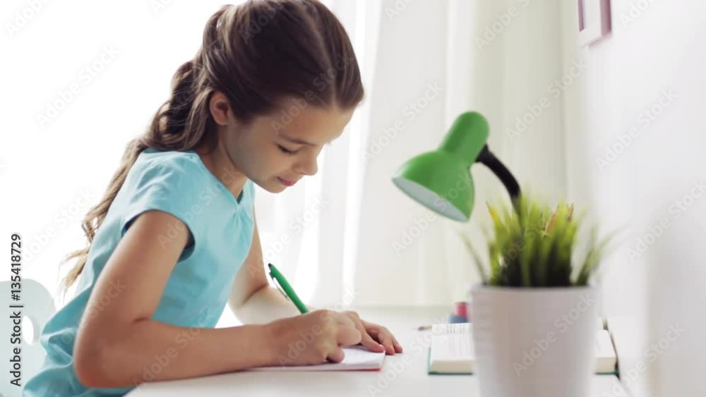 happy girl with book writing to notebook at home happy girl with book writing to notebook at home