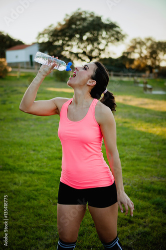 Athlete woman with sportswear drinking water