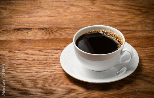 Coffee cup and saucer on a wooden table.