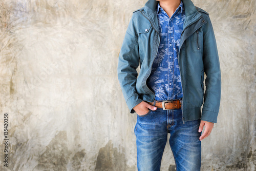 Closeup Men casual outfits standing and denims holds his hands in pockets. Concrete background with space for texture. men beauty and fashion concept, Jeans concept
