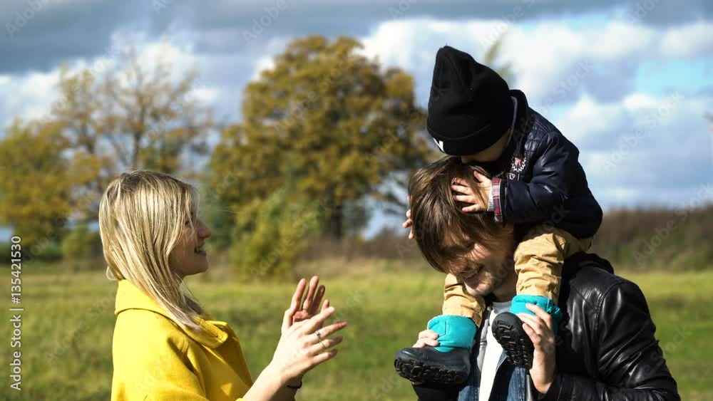 Happy mother, father and little son walking in autumn park and having fun.Happy young family spending time together outside in green nature.Happy family enjoying life together at meadow outdoor.Family Happy mother, father and little son walking in autumn park and having fun.Happy young family spending time together outside in green nature.Happy family enjoying life together at meadow outdoor.Family