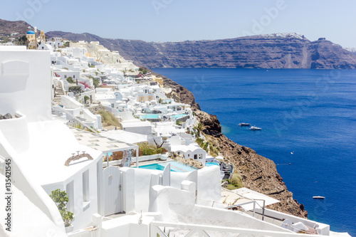 Beautiful view with traditional white buildings over the village of Oia at the Island Santorini, Greece on the Mediterranean sea and rock background