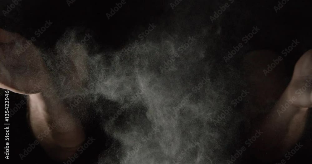 SLOW MOTION closeup of an athlete hands clapping with white chalk powder