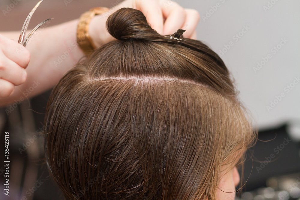 Fototapeta premium hairdresser comb female client's wet hair