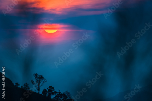 Silhouette tree and monutains background orange sky , at time su photo