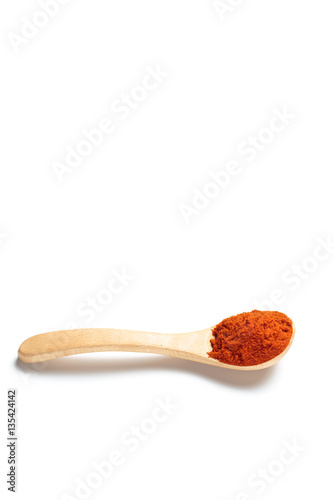 Chili powder in a wooden spoon isolated over white background