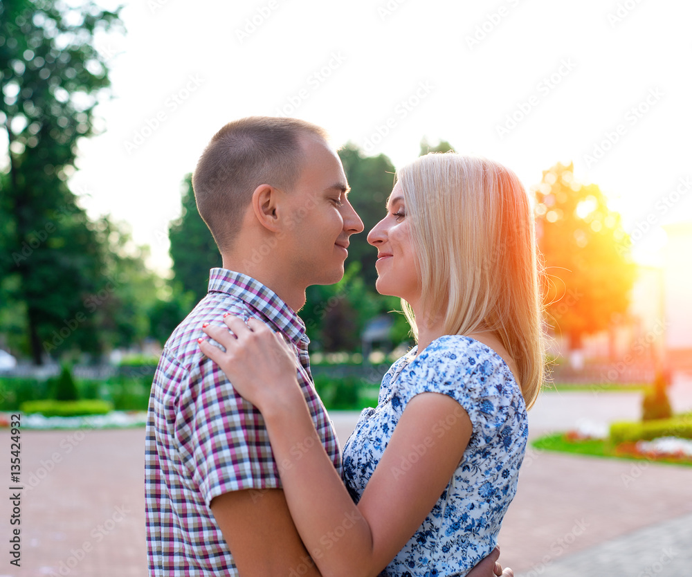 Fototapeta premium Young couple, man and woman looking at each other a bright sunny day in city of the great outdoors, happy family concept, idea good relationship. Smile smotryad .