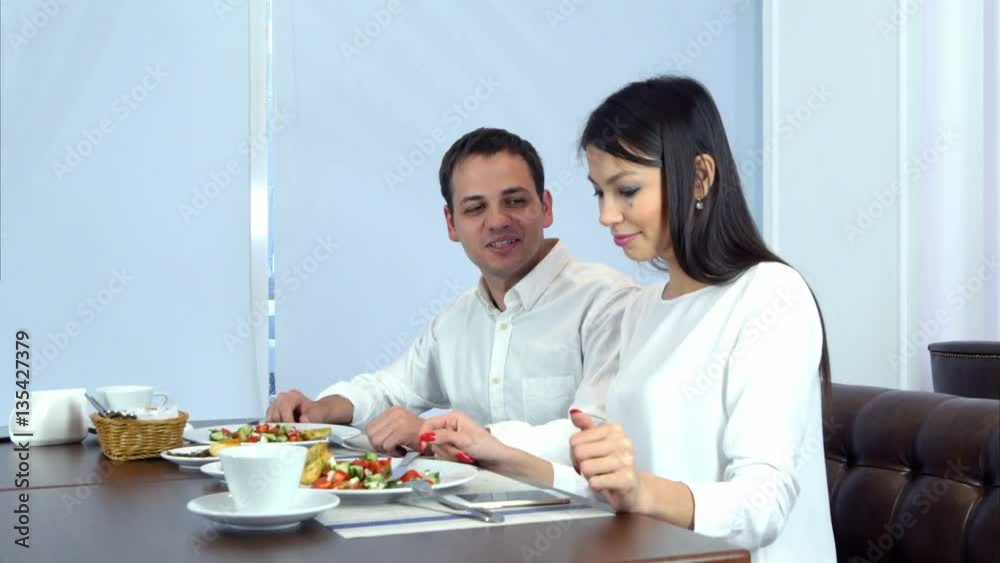 Happy young couple paying bill brought by waiter and leaving cafe Happy young couple paying bill brought by waiter and leaving cafe