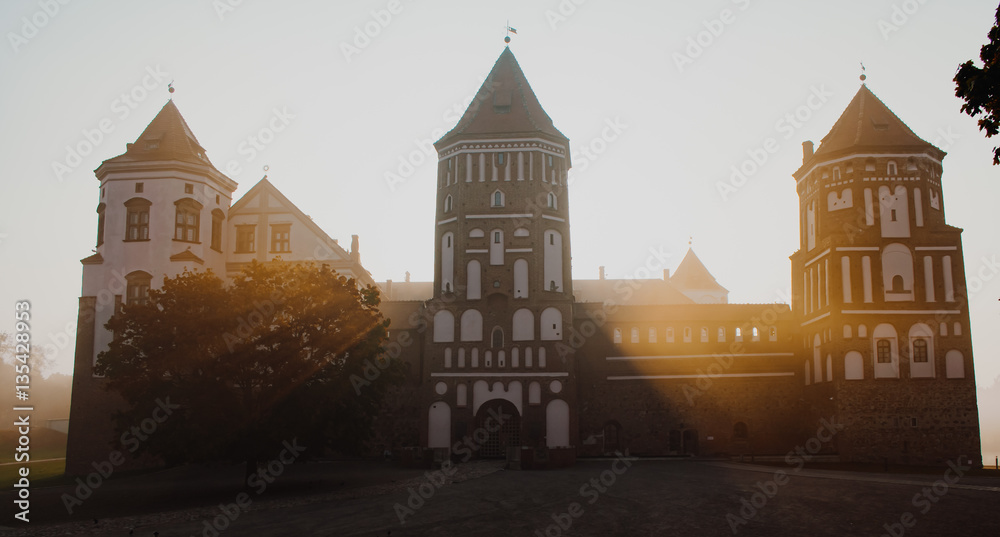 Mir Castle at dawn, on the background of beautiful scenery. Mir city, Belarus. / Mir Castle at sunrise