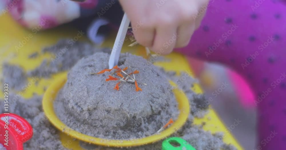 Girl Decorates the Cake in the Sandbox Girl Decorates the Cake in the Sandbox