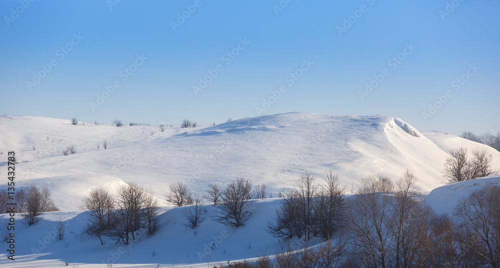 Fototapeta premium Panoramic view of snow-covered hills in central Russia. Winter s