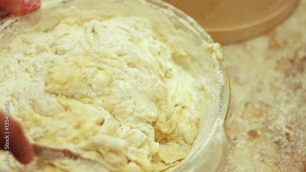 Female hands kneading dough in flour on table Female hands kneading dough in flour on table