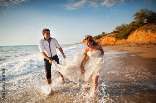 Romantic couple having fun on the beach. Young  in love, Attractive man and woman enjoying  evening  the , Holding hands watching the sunset