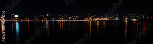 Panorama of night city lights and reflections on lake at Ternopi