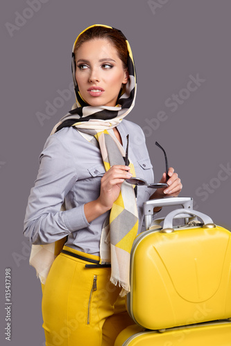 Portrait of trendy young woman in elegant yellow cloth standing