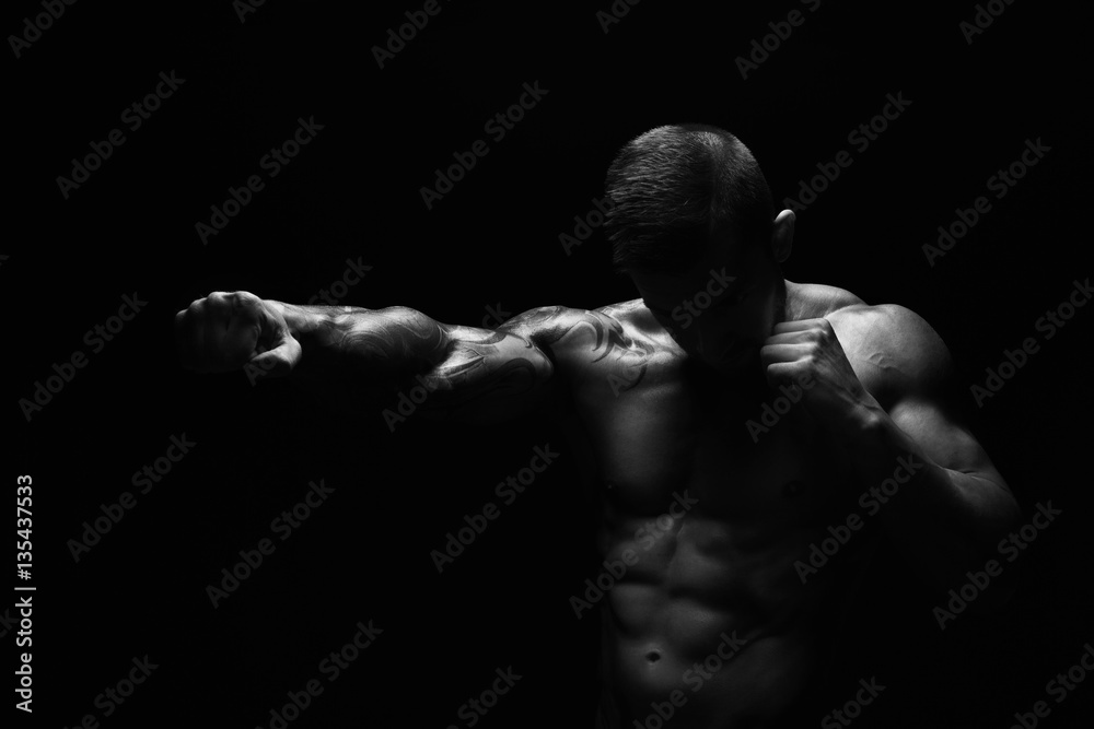 Strong athletic man with naked muscular body punch