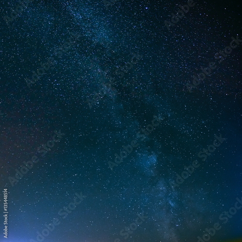 Night Starry Sky Above Field And Yellow City Lights On Backgroun © Grigory Bruev