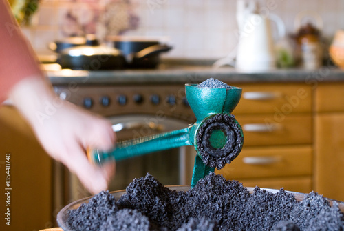 Chef grinds poppy with poppy seed grinder photo