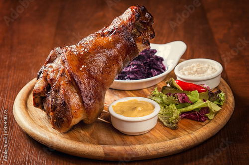 Photography Roasted knuckle of pork with boiled cabbage, horseradish and mustard on wooden b