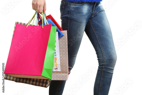 Close-up of female legs with shopping bags in their hands.