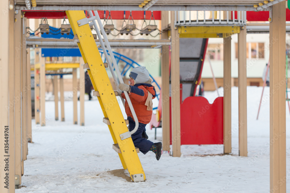 Gomel, Belarus - 31 January 2017: A boy plays on the playground in the winter time.