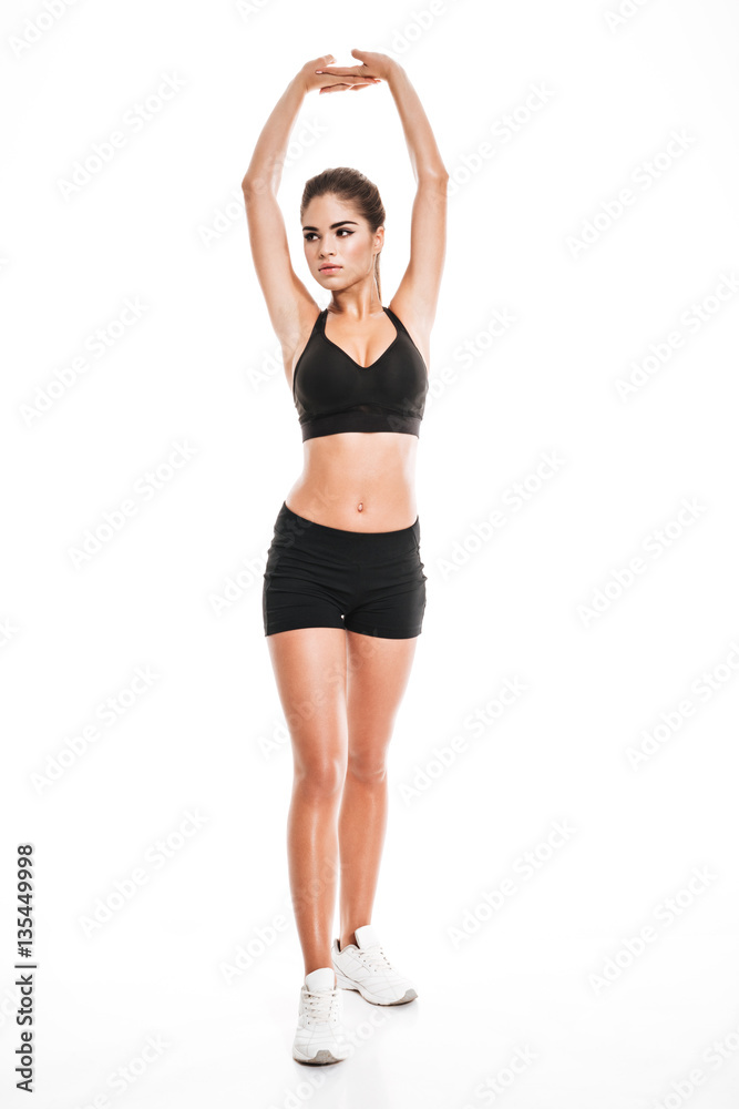 Full length of graceful woman athlete standing and stretching hands Full length of graceful woman athlete standing and stretching hands