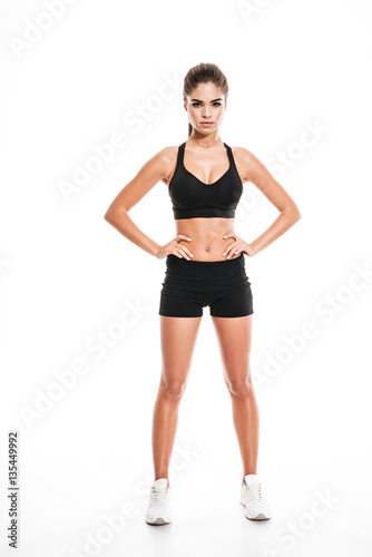 Full length of fitness woman standing with hands on waist