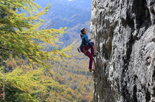 A woman rock climbing at Ogawayama, a mountain on the border of Nagano and Yamanashi prefectures, Honshu, Japan