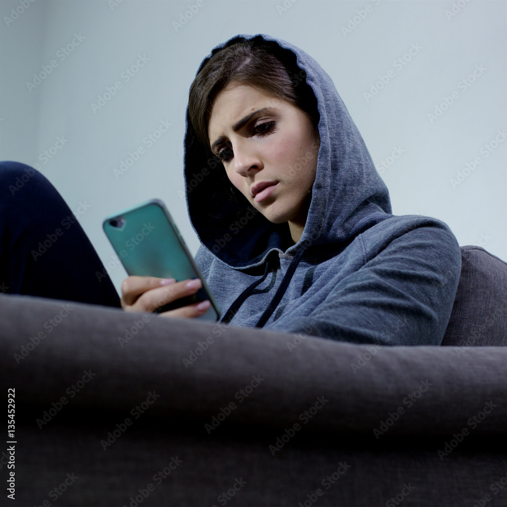 Woman sad bullied on the internet looking message on social network closeup Woman sad bullied on the internet looking message on social network closeup