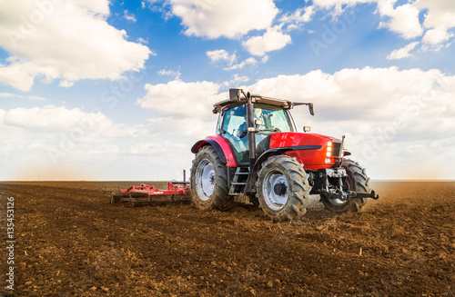 Farmer in tractor preparing land with seedbed cultivator