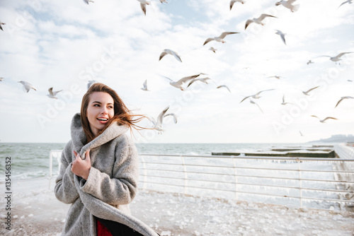 Smiling woman standing on pier in winter