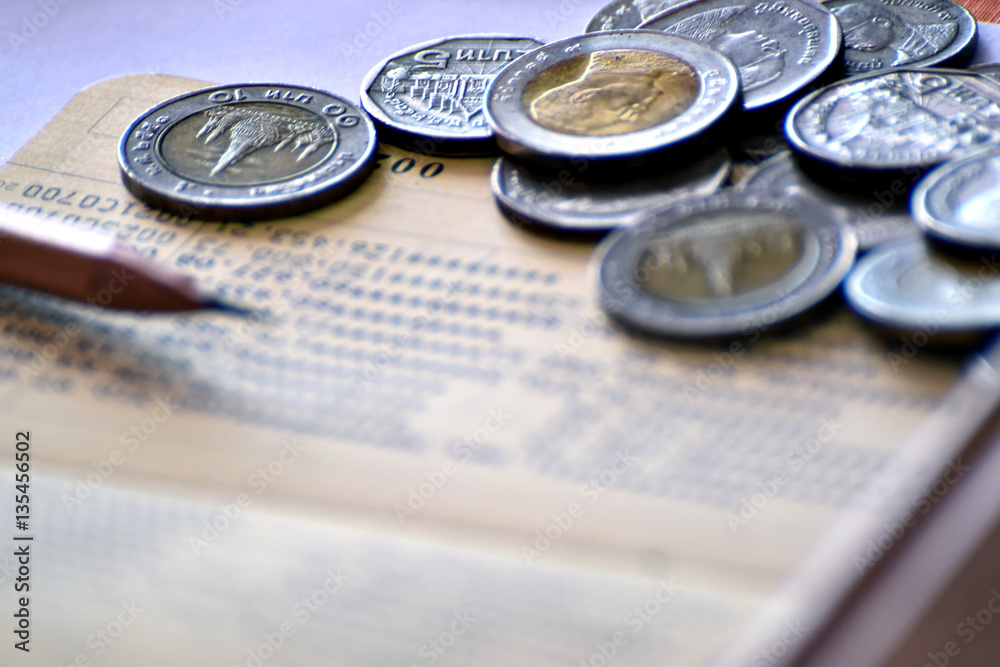 Baht coins, deposit accounts, pen, concept of saving money. Baht coins, deposit accounts, pen, concept of saving money.