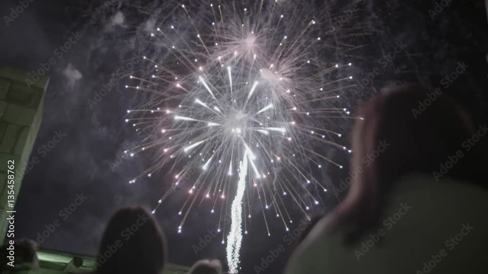 Slow motion shot of a crowd of people watching huge fireworks, view from the back. Holiday backgrounds. Lunar New Year Celebration.