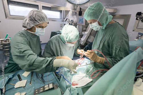 Neurosurgeons opening the cranium during an operation photo