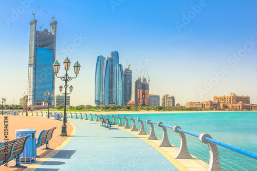 Dhabi skyline from cycle paths of Corniche. Abu Dhabi, United Arab Emirates, Middle East. Modern skyscrapers and landmark on background. Summer holidays concept. photo