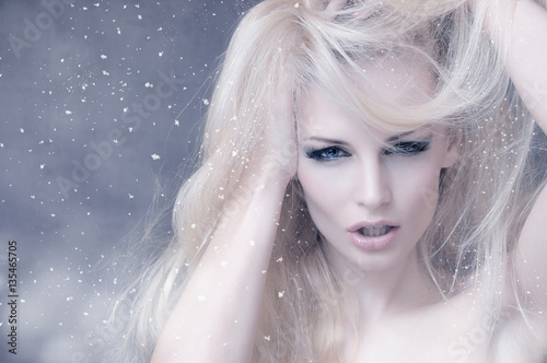 Fototapeta Naklejka Na Ścianę i Meble -  Portrait of a blonde girl with falling snowflakes
