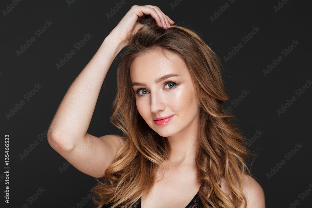 Pretty young woman standing over grey background
