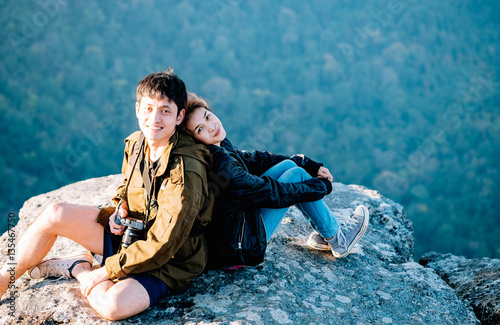 asian couple sitting together on mountain