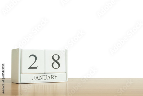 Closeup surface white wooden calendar with black 28 january word on blurred brown wood desk isolated on white background with copy space , selective focus at the calendar