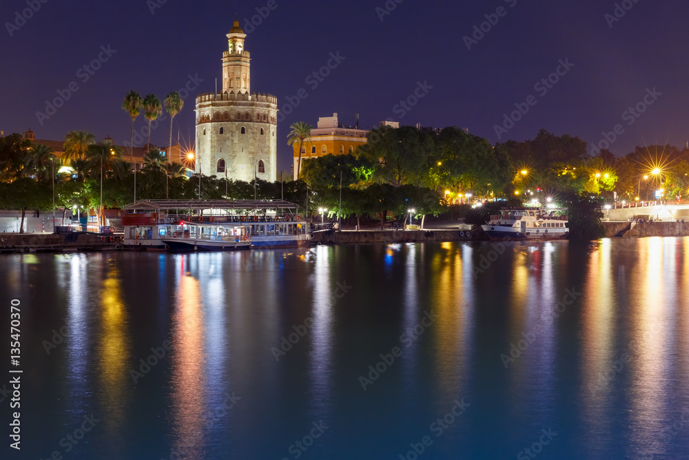 Dodecagonal military watchtower Golden Tower or Torre del Oro and Guadalquivir river during evening blue hour, Seville, Andalusia, Spain