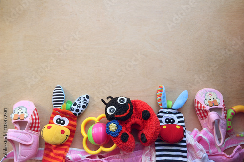 Детские игрушки и обувь на деревянном фоне