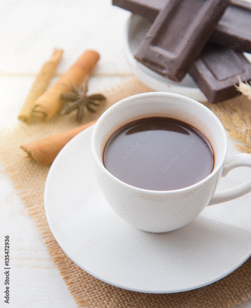 Hot Chocolate in white cups with Chocolate bar on the wooden table Hot Chocolate in white cups with Chocolate bar on the wooden table