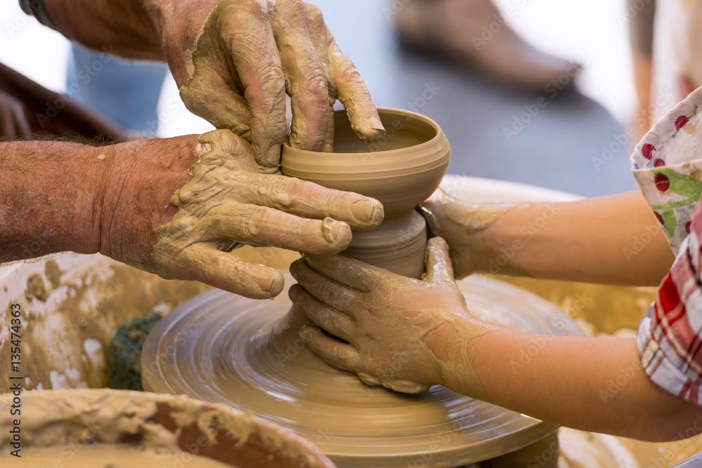 Close-up of a potter's wheel, teaching a child to make a clay object