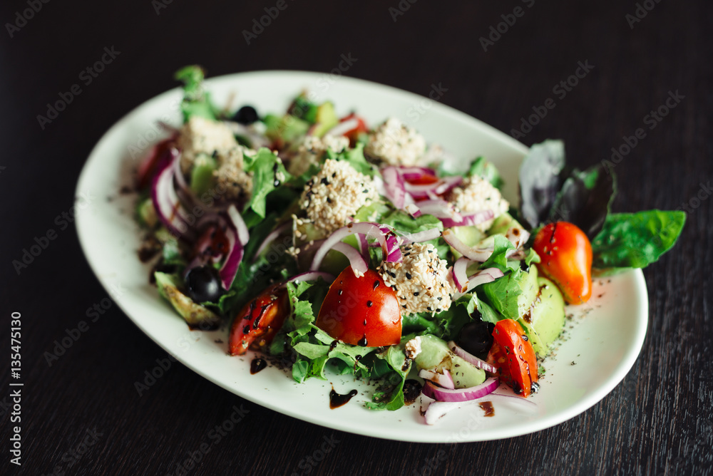 Salad with greens,cheese and onions on a white dish Salad with greens,cheese and onions on a white dish