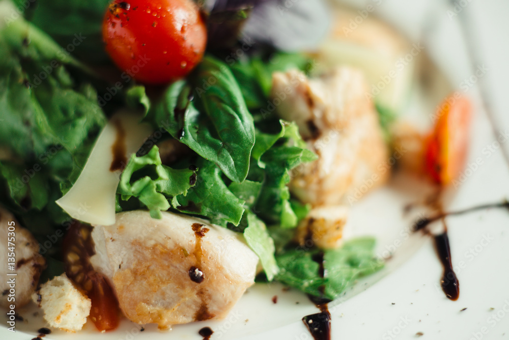 Caesar salad with chicken on white dish Caesar salad with chicken on white dish