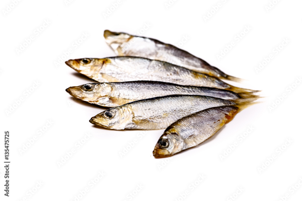 The Azov sprat (whitebait) are small fish salted lies on a white The Azov sprat (whitebait) are small fish salted lies on a white