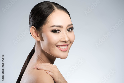 Beauty shot of young pretty asian woman with clear skin ongrey b photo